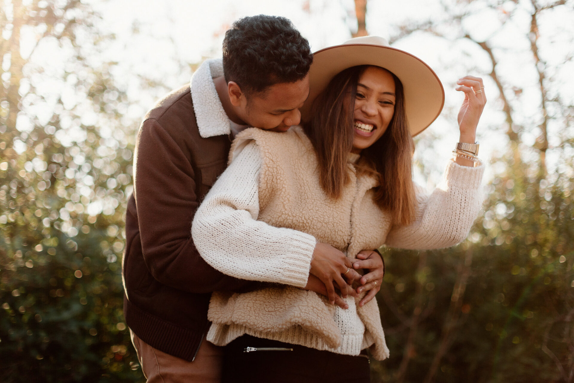 Couple qui éclate de rire dans la lumière dorée de l'automne