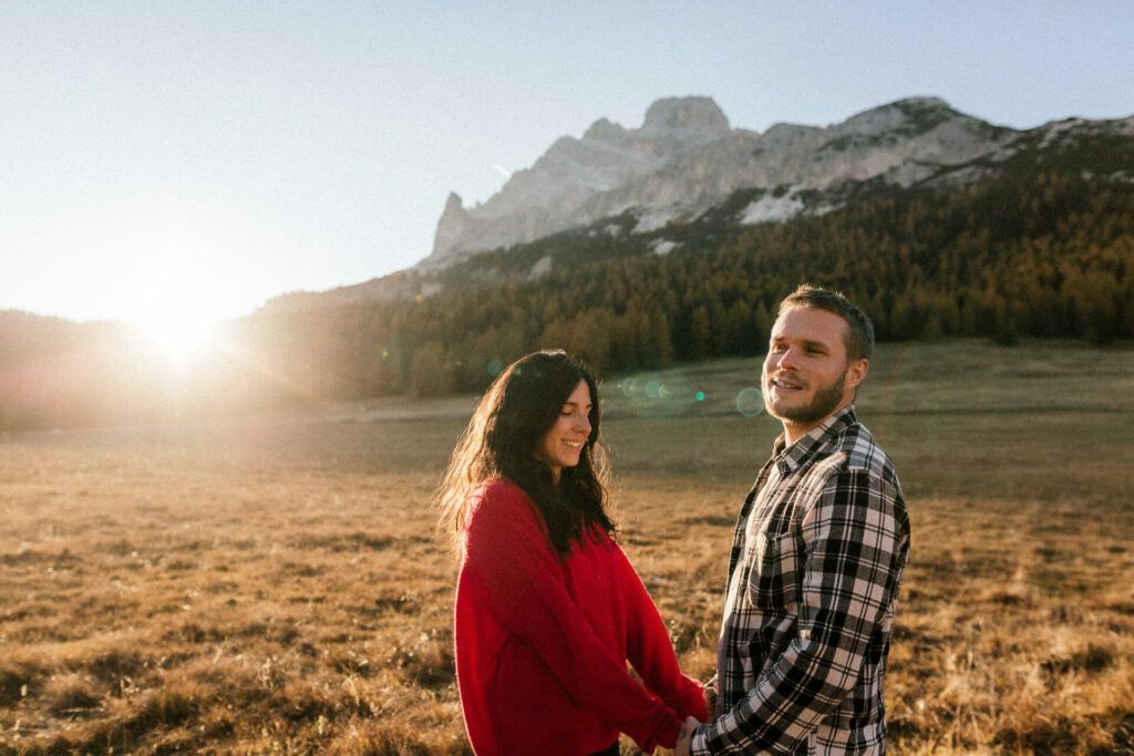 Jeune femme en pull rouge dans une prairie de montagne