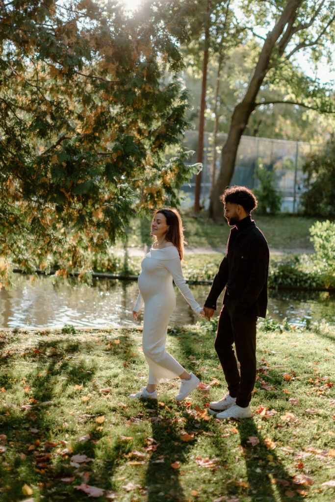 Futurs parents main dans la main dans un parc en automne